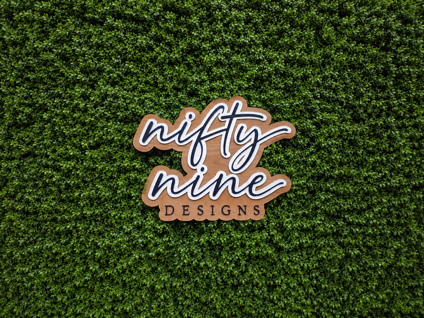 Logo of 'nifty nine DESIGNS' on a green textured background