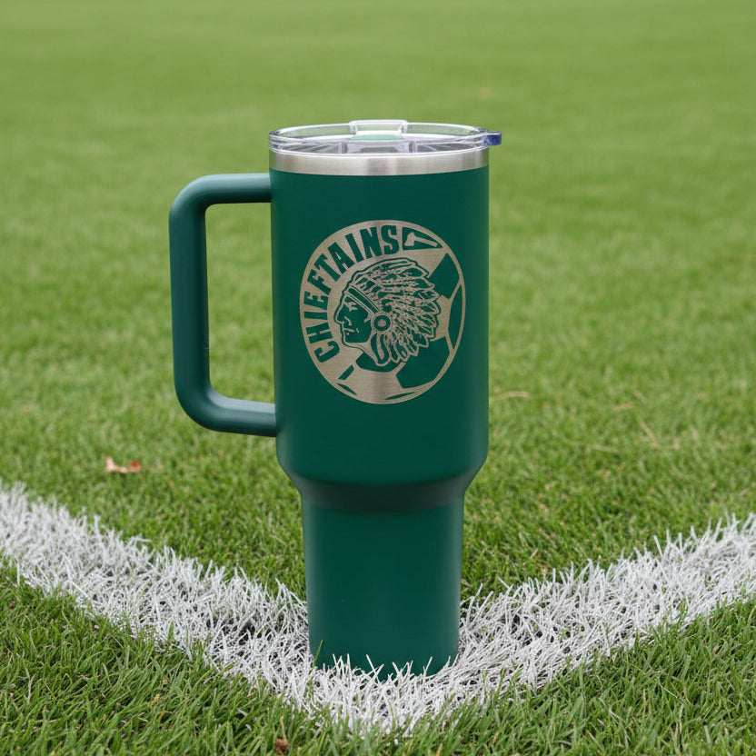 Green mug with a logo on a grass field